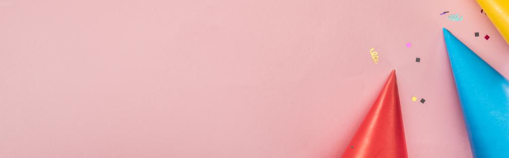 Plan panoramique de chapeaux de fête et confettis sur fond rose
 - Photo, image