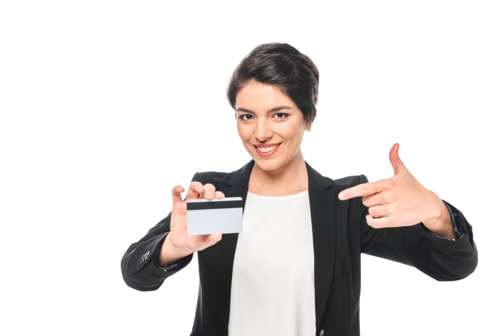 Veselý smíšený závod, obchodní žena ukazující prstem na kreditní kartu a pohled na fotoaparát izolovaný na bílém - Fotografie, Obrázek