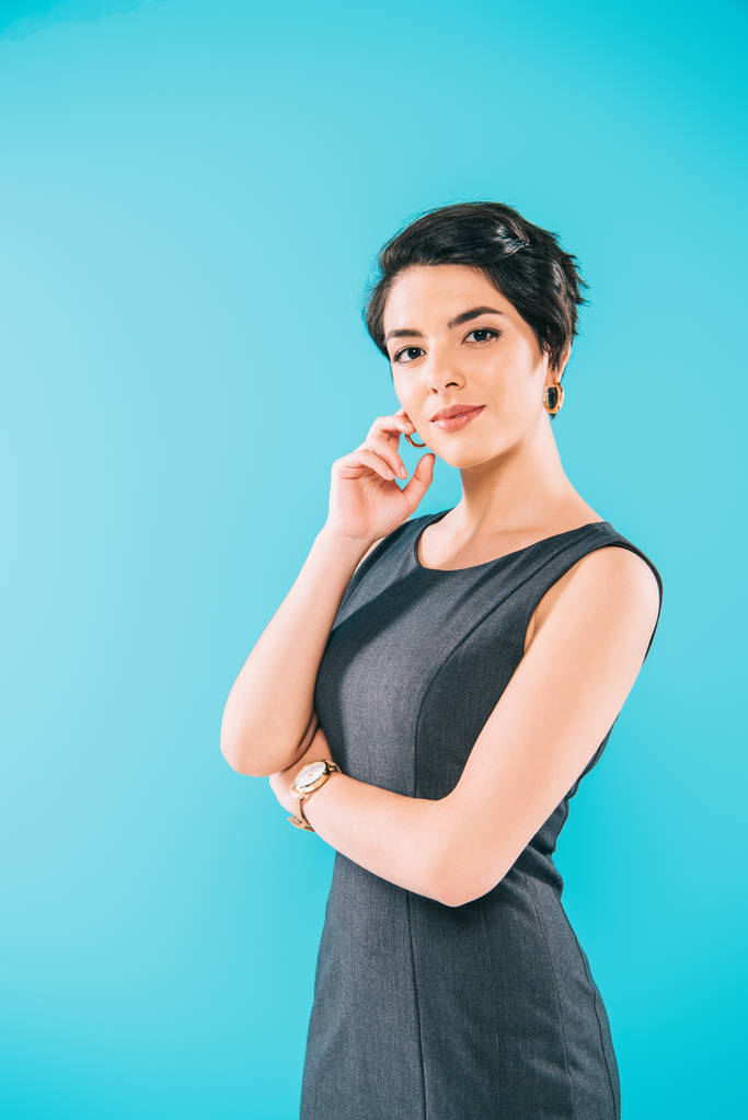 beautiful mixed race woman posing at camera with hand near face isolated on blue - Photo, Image