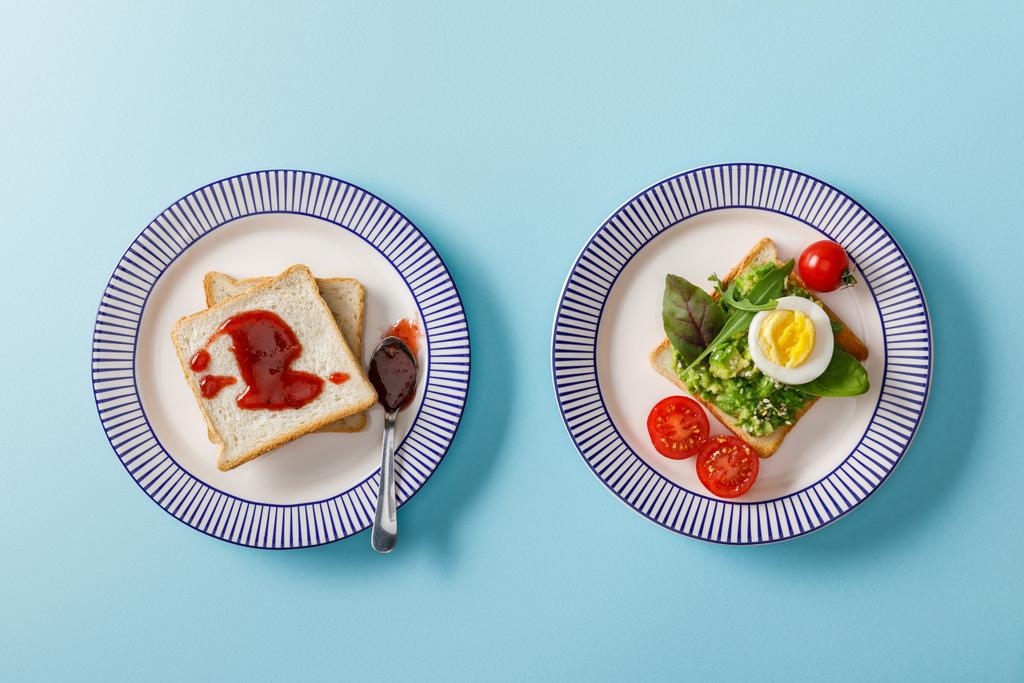 top view of served breakfast, toasts with guacamole and jam on blue background - Photo, Image