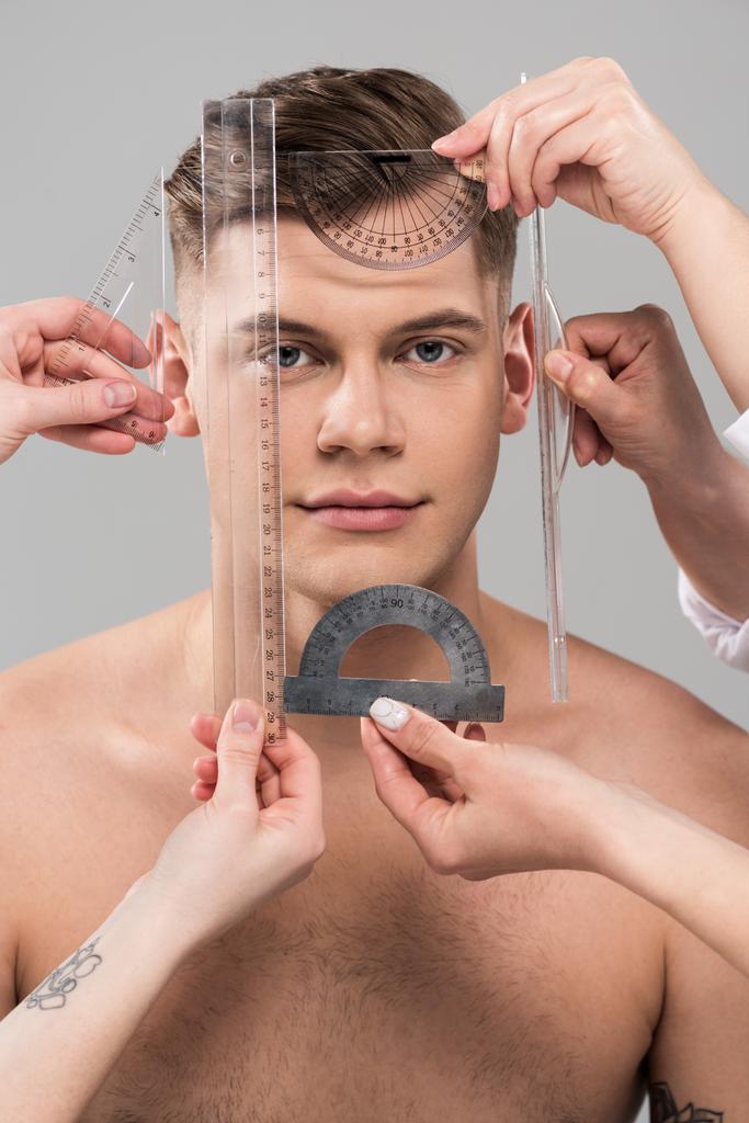 κομμένη όψη των πλαστικών χειρουργών που μετρούν το πρόσωπο με τους χάρακες και τους προελκυστήρες που απομονώνονται σε γκρι - Φωτογραφία, εικόνα