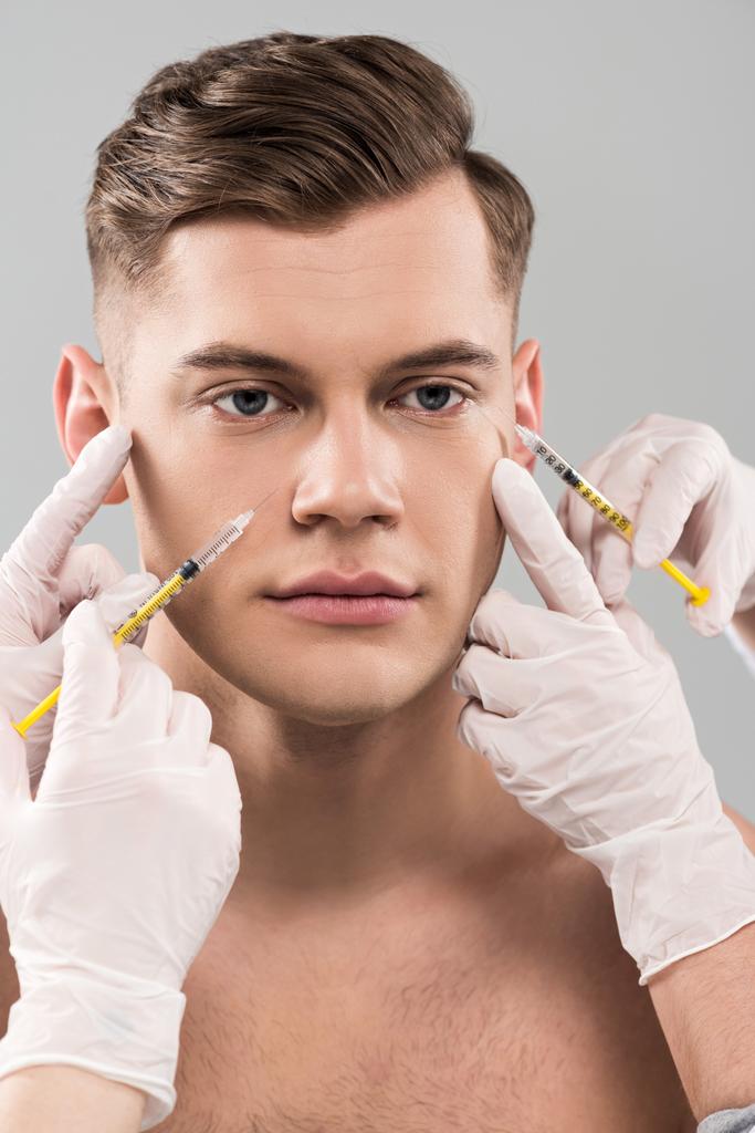 cropped view of cosmetologists in latex gloves doing beauty injections isolated on grey - Photo, Image