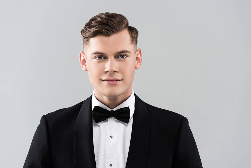 вид спереду усміхненого молодого чоловіка в офіційному одязі з краваткою ізольовано на сірому
 - Фото, зображення