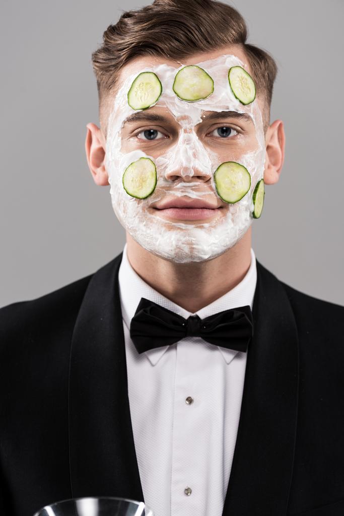 giovane in abito formale con cetriolo maschera facciale isolato su grigio
 - Foto, immagini