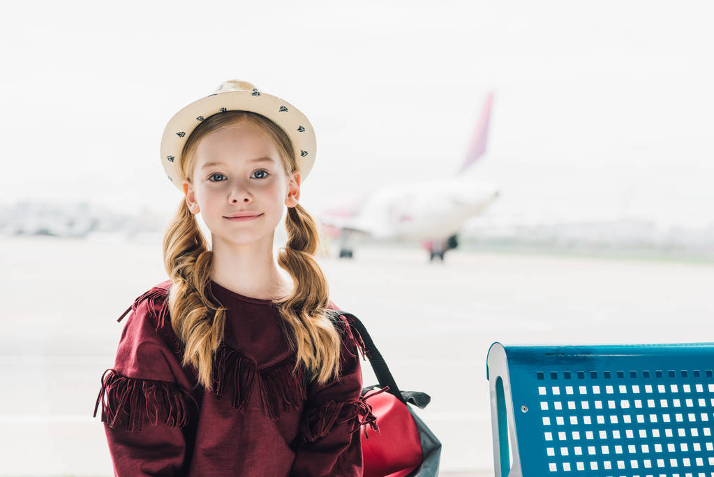 восхитительный дошкольник смотрит на камеру в аэропорту
 - Фото, изображение