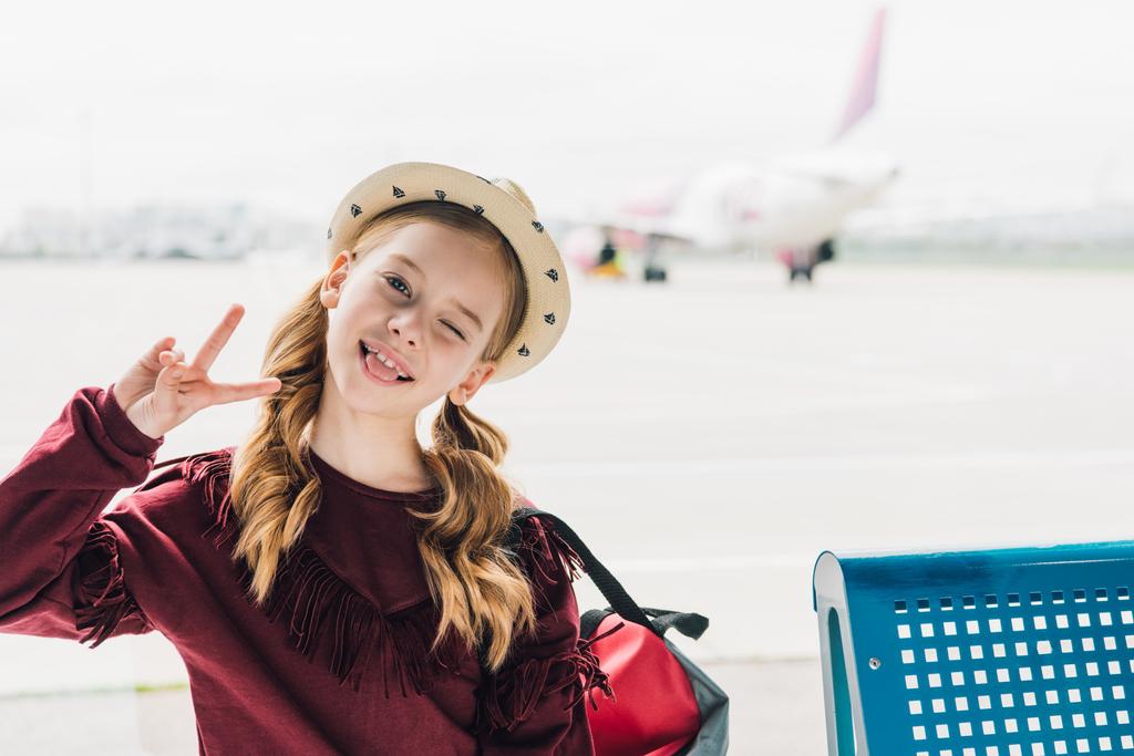 mignon préadolescent enfant collant sur la langue et montrant la paix Connexion aéroport
 - Photo, image