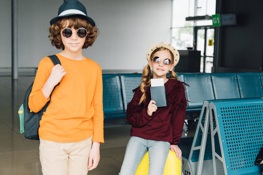 милий дев'ятнадцять дітей в сонцезахисних окулярах в залі очікування з рюкзаком, авіаквитком і паспортом
 - Фото, зображення