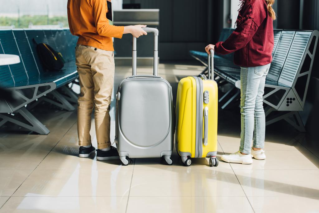 Задний вид на подростков с чемоданами в зале ожидания
 - Фото, изображение