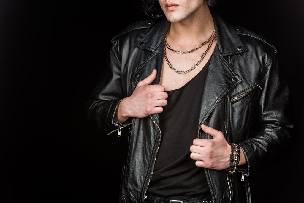 cropped view of young man touching leather jacket isolated on black  - Photo, Image