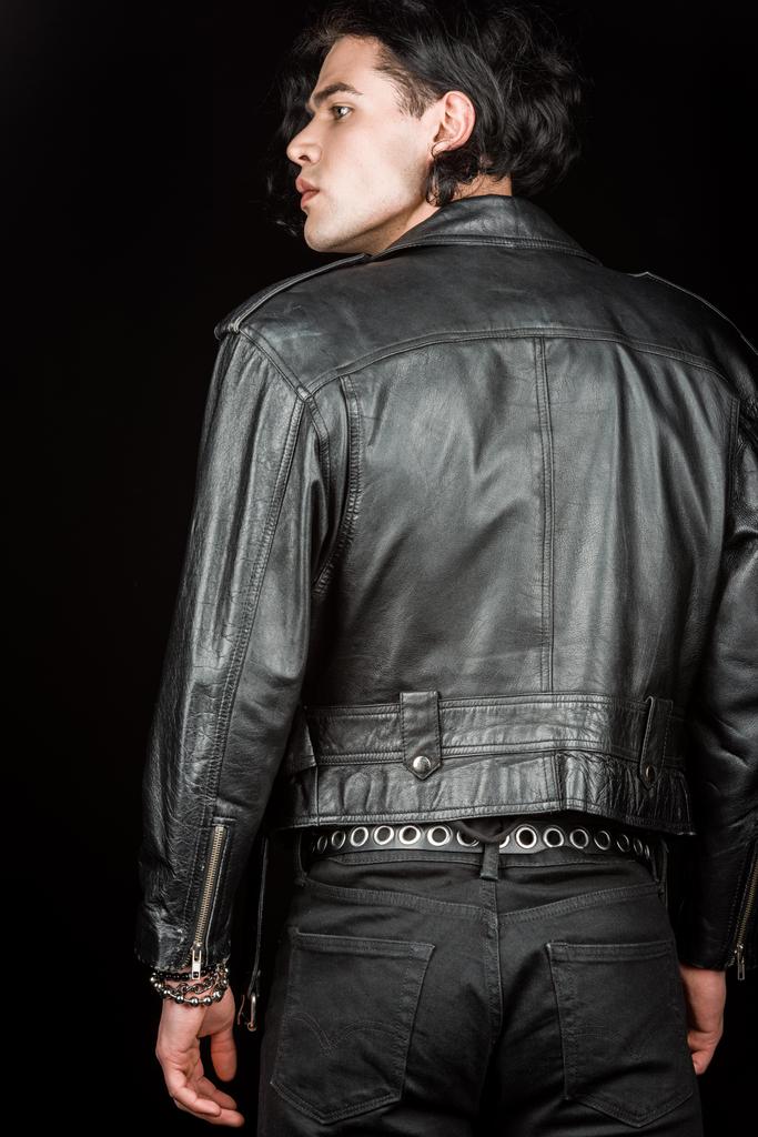 серйозна людина в шкіряній куртці стоїть ізольовано на чорному
   - Фото, зображення