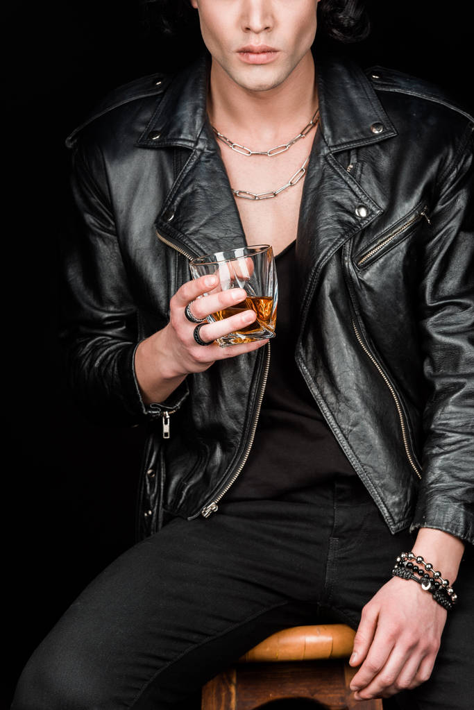 vista recortada del hombre sosteniendo un vaso de whisky mientras está sentado en una silla de madera aislada en negro
  - Foto, Imagen