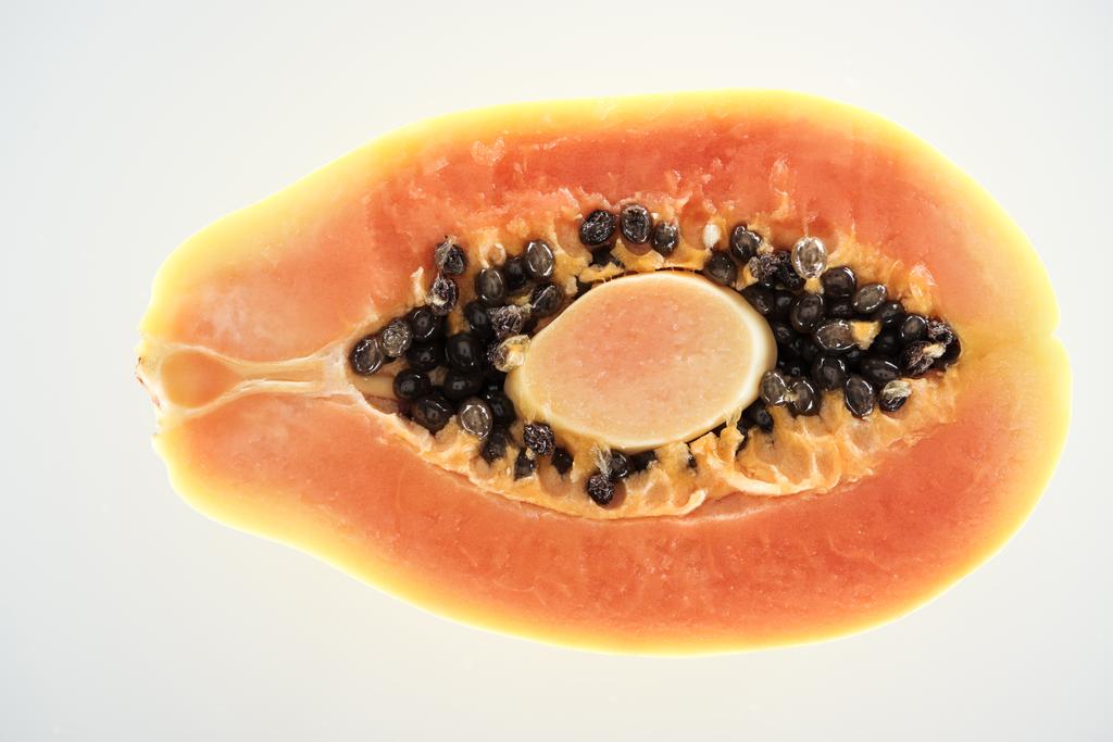 beyaz izole siyah tohumları ile olgun sulu papaya yarısı üst görünümü - Fotoğraf, Görsel
