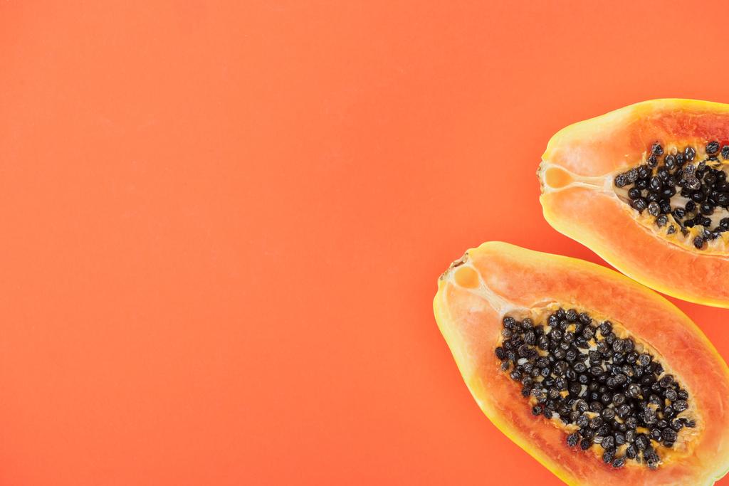 верхний вид спелых экзотических половинки папайи с черными семенами изолированы на оранжевый с копированием пространства
 - Фото, изображение