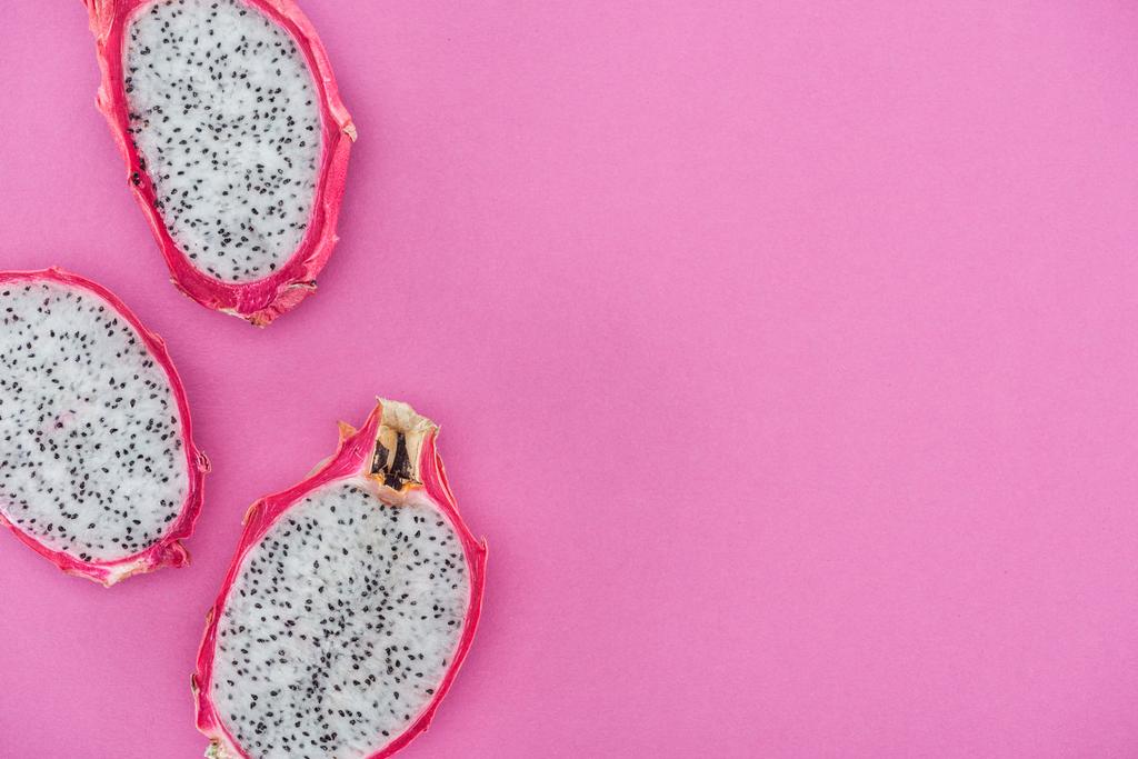 top view of tropical ripe dragon fruit halves on pink background - Photo, Image