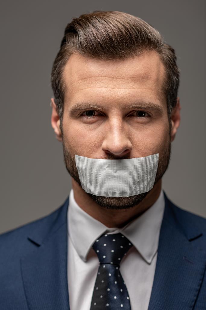 homem de negócios bonito em terno com fita adesiva na boca isolado em cinza
 - Foto, Imagem