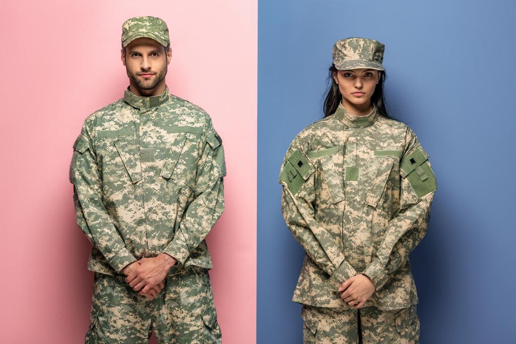 homem e mulher em uniforme militar olhando para a câmera em azul e rosa
 - Foto, Imagem