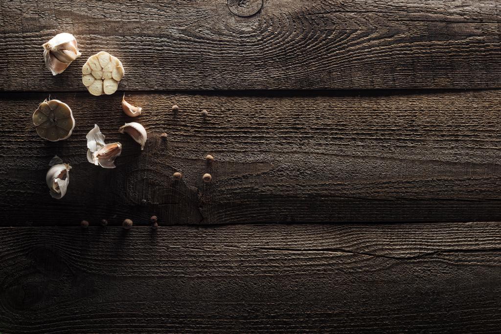 Widok z góry na ząbki czosnku i czarnego pieprzem na drewnianym stole rustykalnym - Zdjęcie, obraz