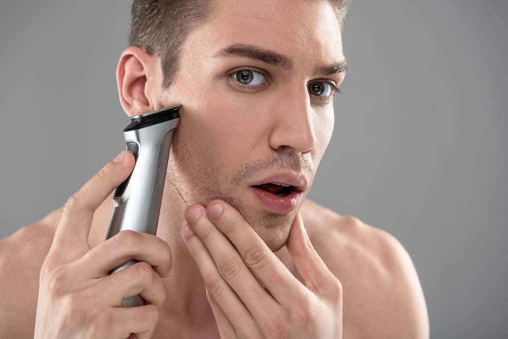 schöner junger Mann rasiert sich mit Rasiermesser - Foto, Bild