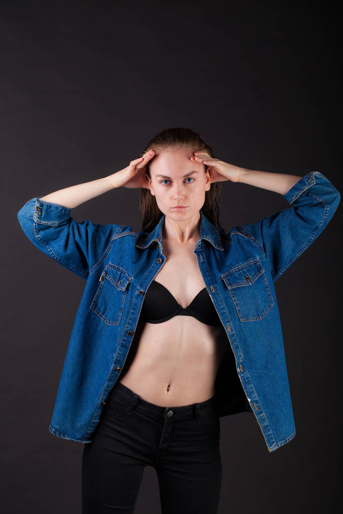 retrato de estúdio de uma jovem muito fina em lingerie com cabelo molhado e jaqueta de jeans
 - Foto, Imagem