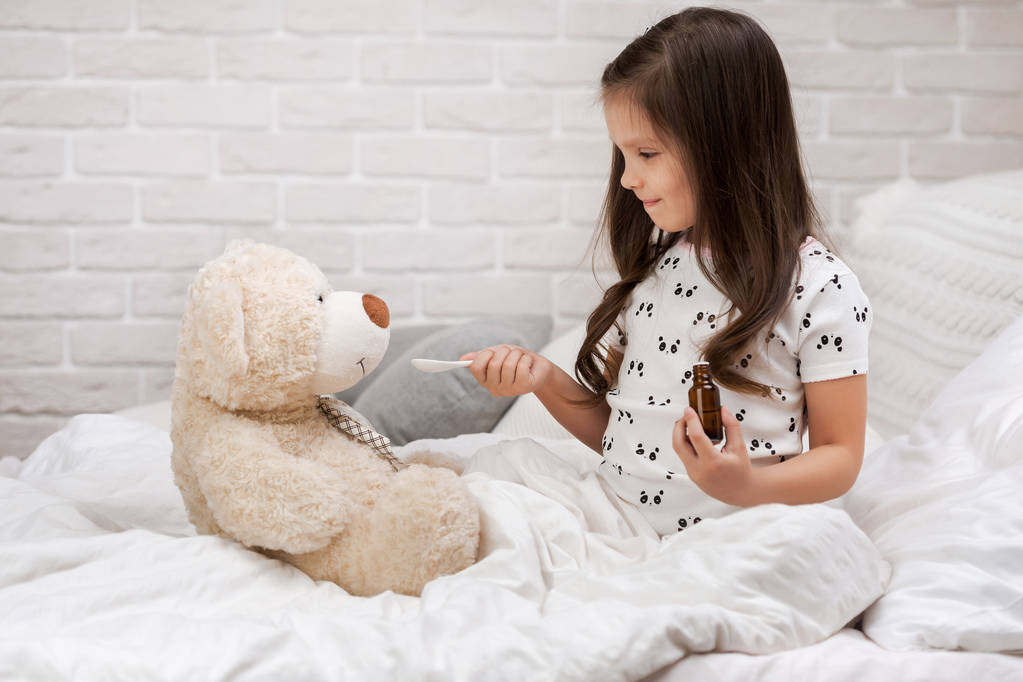 Roztomilá holčička, která si hraje na doktora s medvídkem - Fotografie, Obrázek