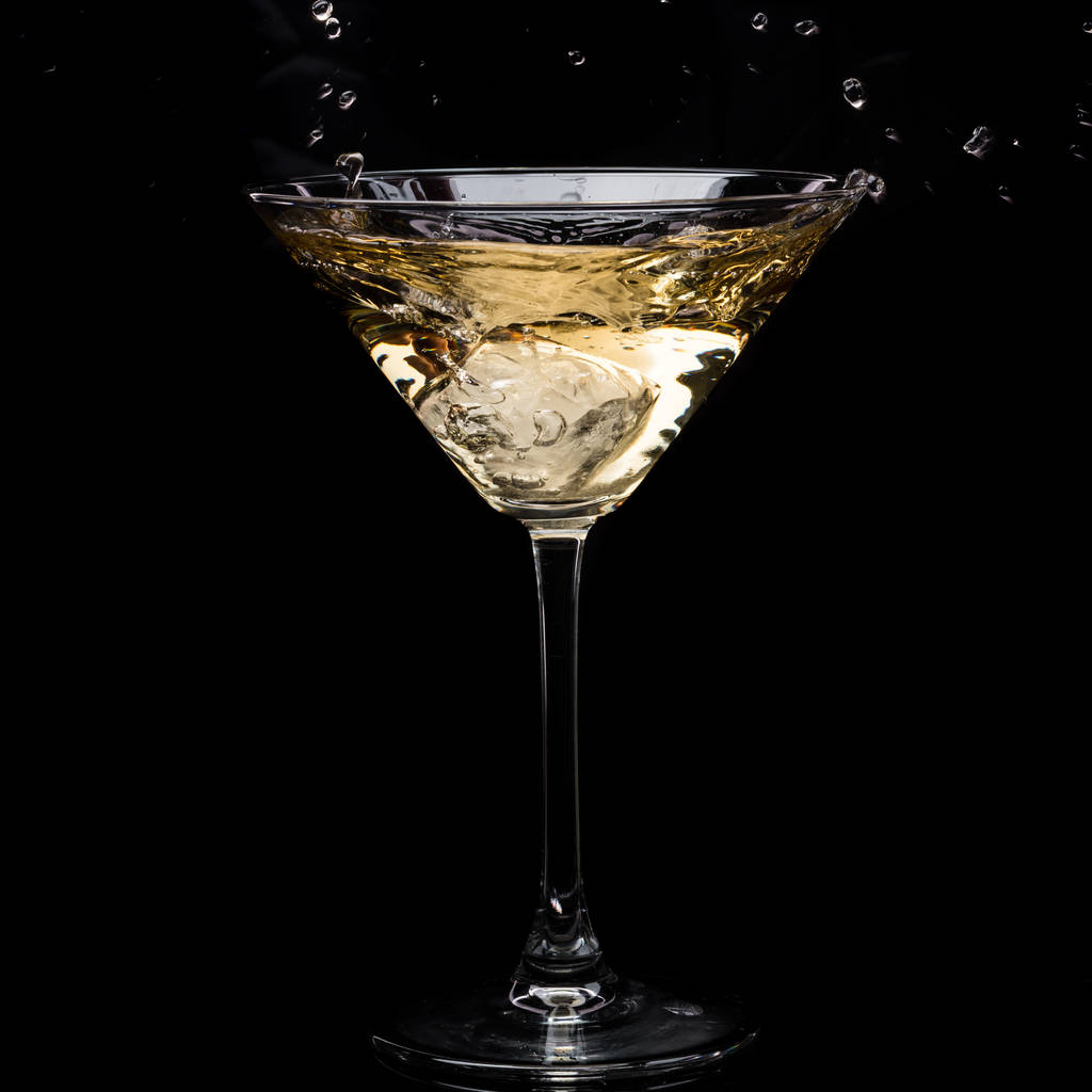 ve skleněném Martini, padá vermut a potřísnění na černém pozadí - Fotografie, Obrázek