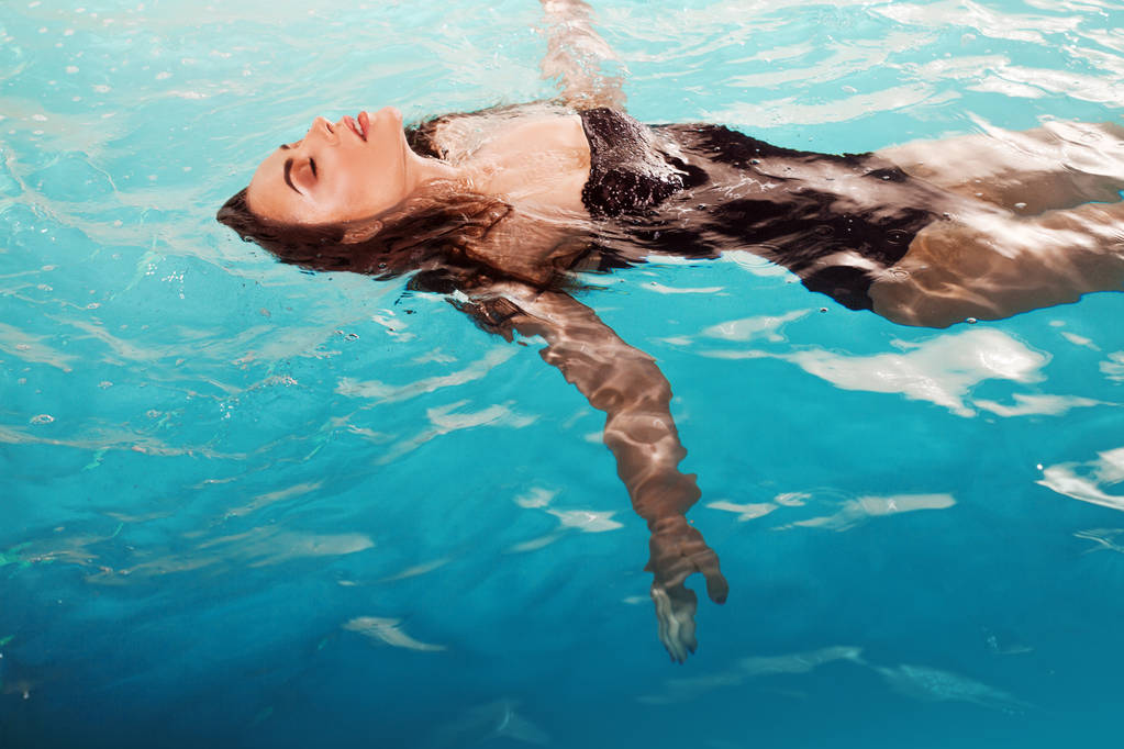 Mladá krásná a štíhlá žena plave v bazénu sama. Lázně a relaxace, luxusní Hotel - Fotografie, Obrázek