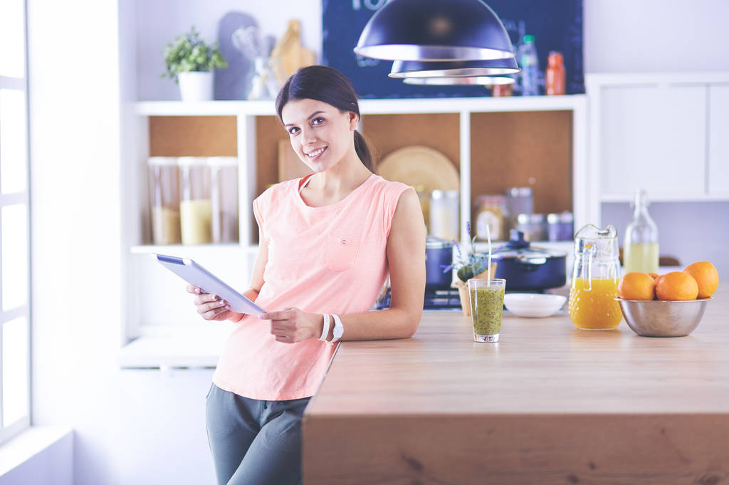 bela jovem mulher usando um tablet digital na cozinha - Foto, Imagem