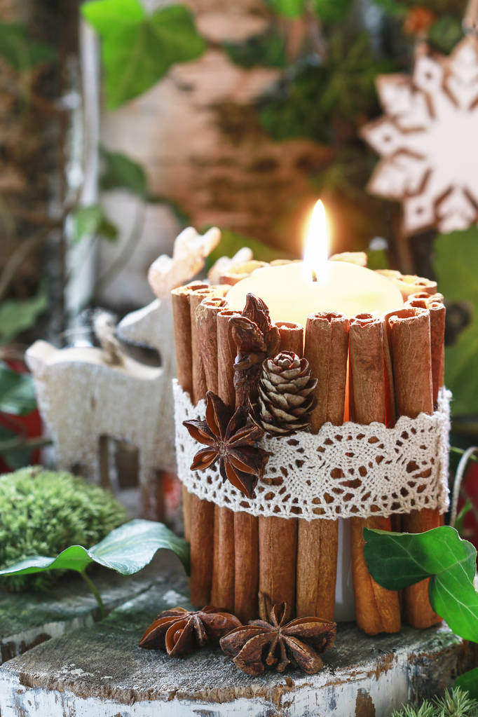 Bougie décorée de bâtonnets de cannelle, mousse, feuilles de lierre et bois
 - Photo, image