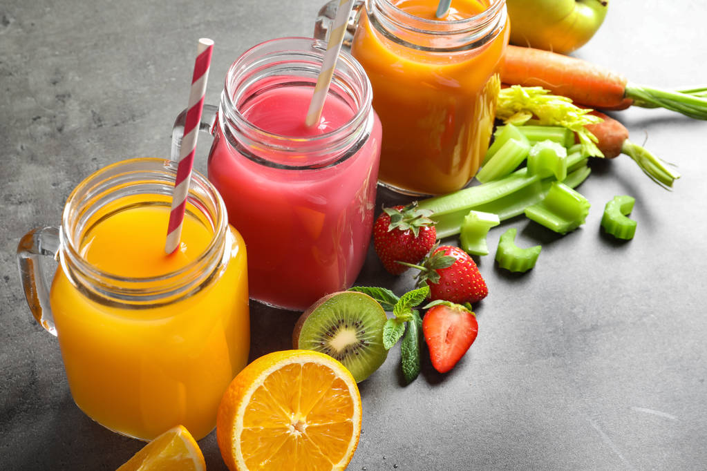 Mason jars with different juices and fresh ingredients on table - Photo, Image