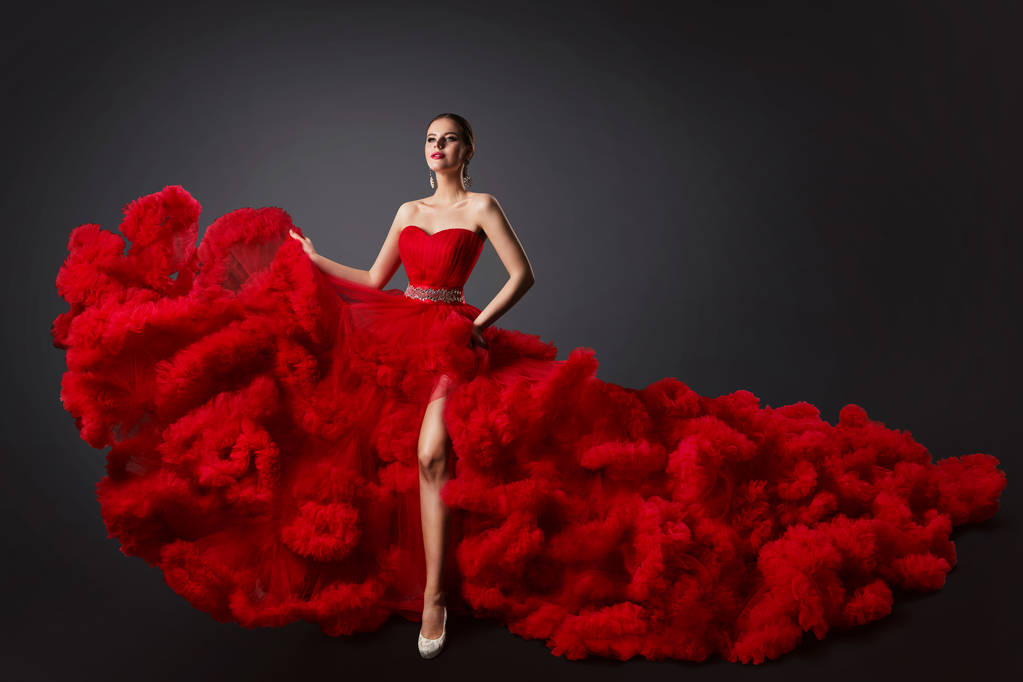 Жінка в червоному хрусткому одязі, модель моди в довгій пухнастій махаючій сукні - Фото, зображення