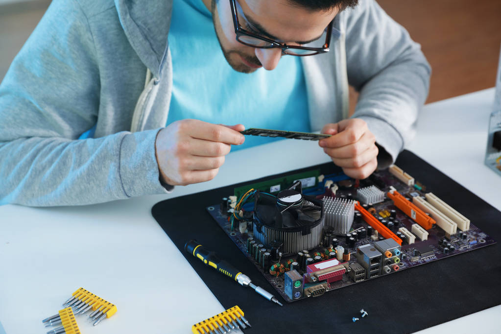 Male technician repairing computer motherboard at table - Photo, Image