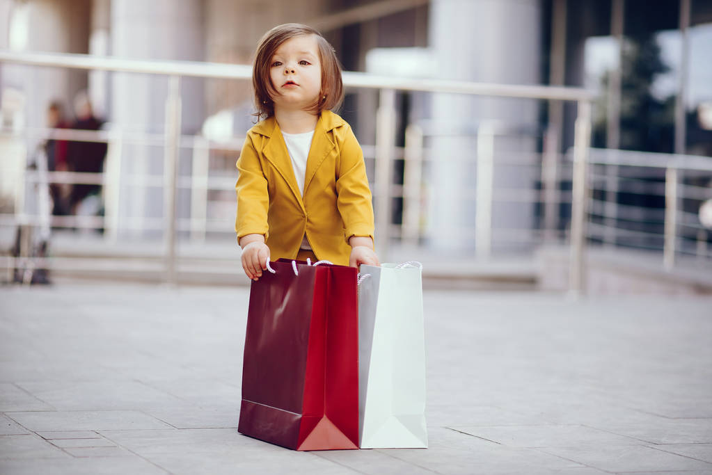 Schattig klein meisje met boodschappentas in een stad - Foto, afbeelding