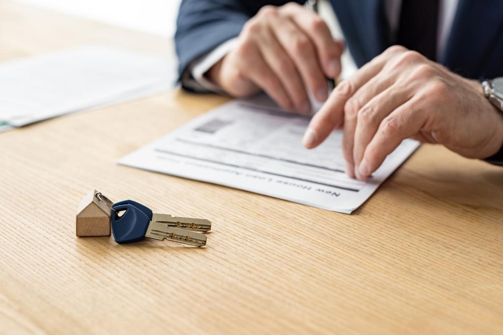 вибірковий фокус дилера будинку, що тримає ручку біля контракту та ключа автомобіля
  - Фото, зображення