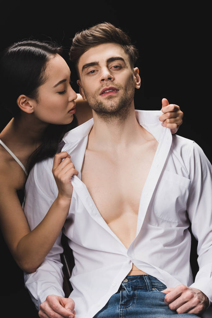 сексуальна азіатська жінка роздягається красивий хлопець ізольовано на чорному
 - Фото, зображення