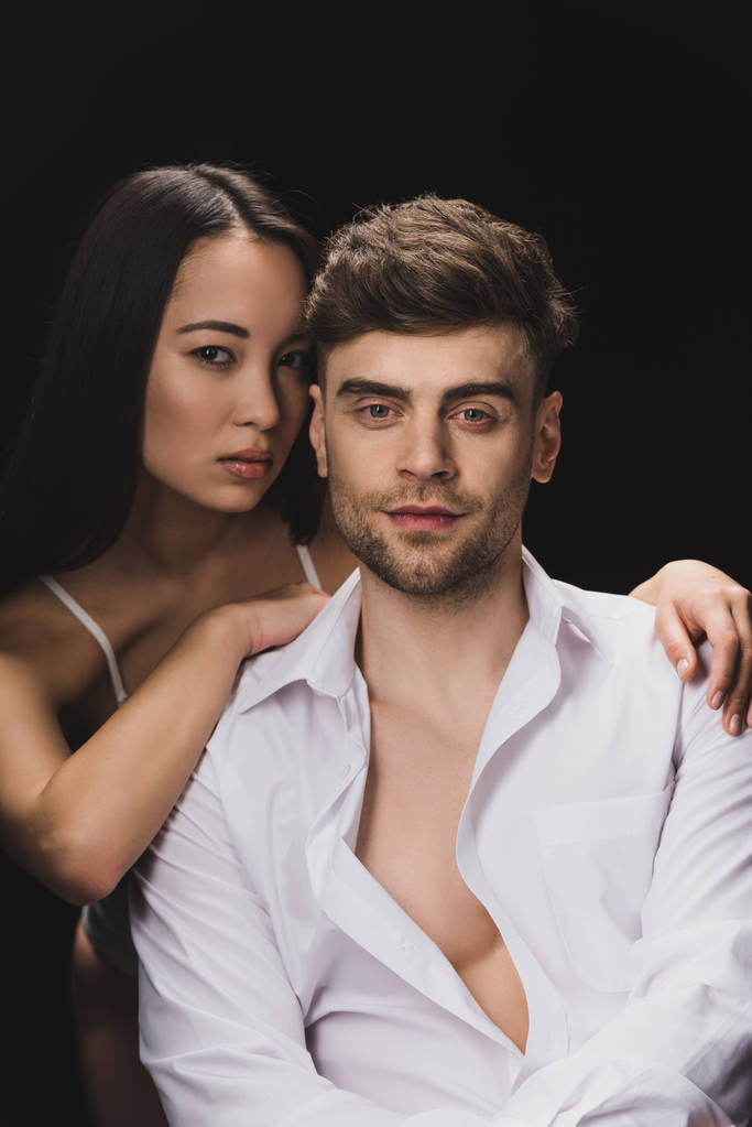сексуальная азиатка обнимает красивого мужчину изолированного от черного
 - Фото, изображение