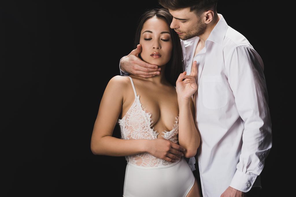 bello giovane uomo abbracciando sexy asiatico ragazza in bianco lingerie isolato su nero
 - Foto, immagini