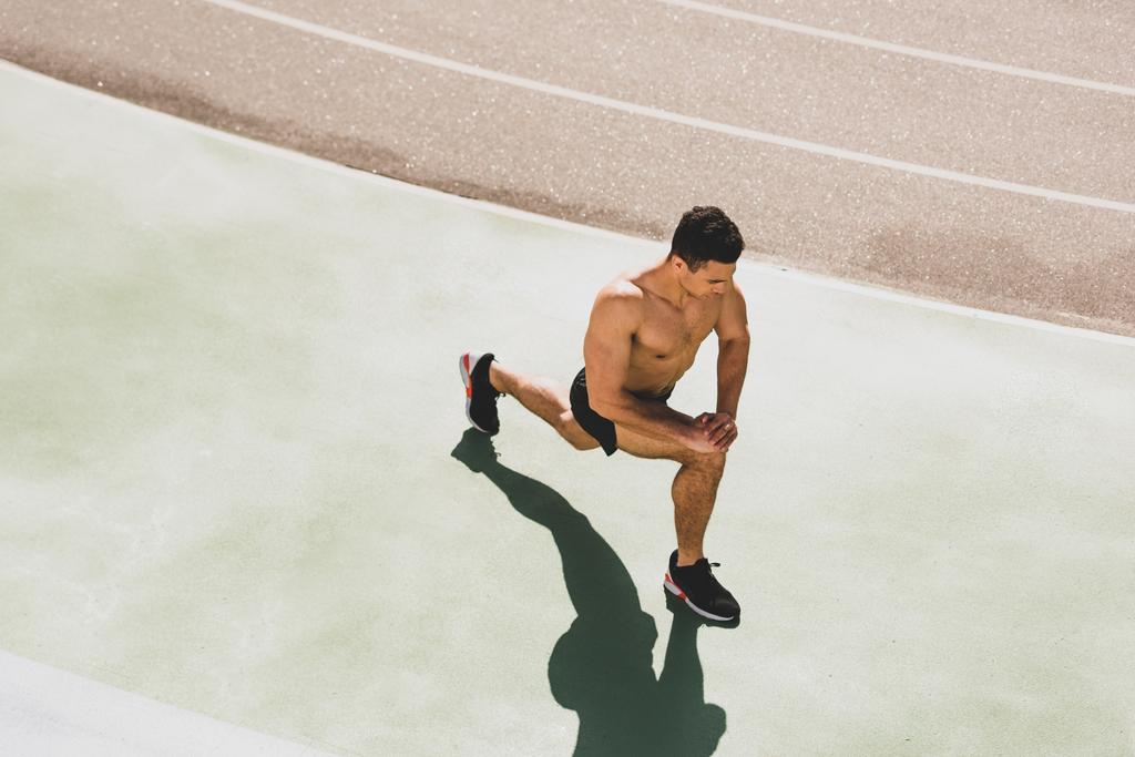 stadyumda uzanan gömleksiz karışık yarış sporcusu havai görünümü - Fotoğraf, Görsel