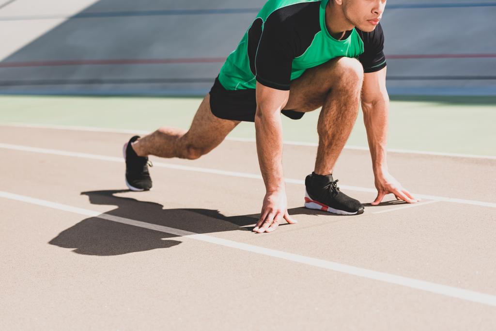 vista recortada del deportista que se prepara para correr en el estadio
 - Foto, Imagen