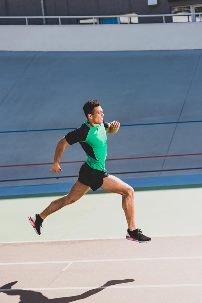 vista completa del deportista de carrera mixta corriendo en el estadio
 - Foto, imagen