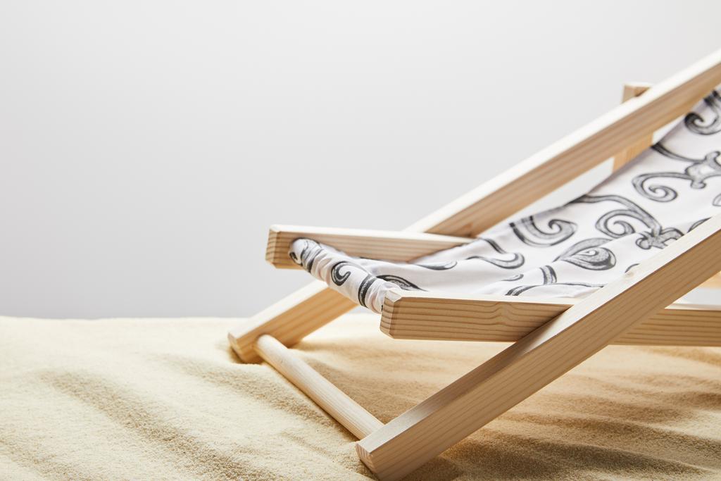 tumbona de madera sobre arena sobre fondo gris con espacio para copiar
 - Foto, imagen