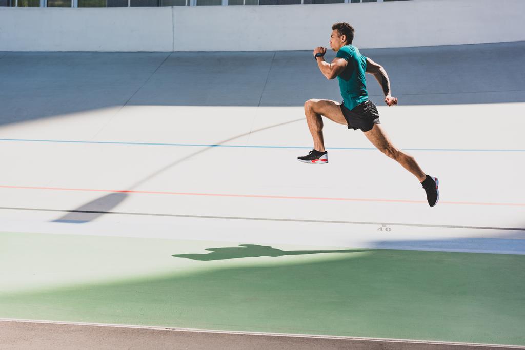 вид збоку змішаної гонки спортсмен біжить на стадіоні
 - Фото, зображення