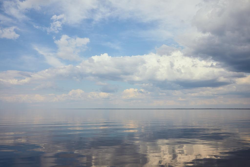 Nyugodt tó és világoskék ég, fehér felhők - Fotó, kép
