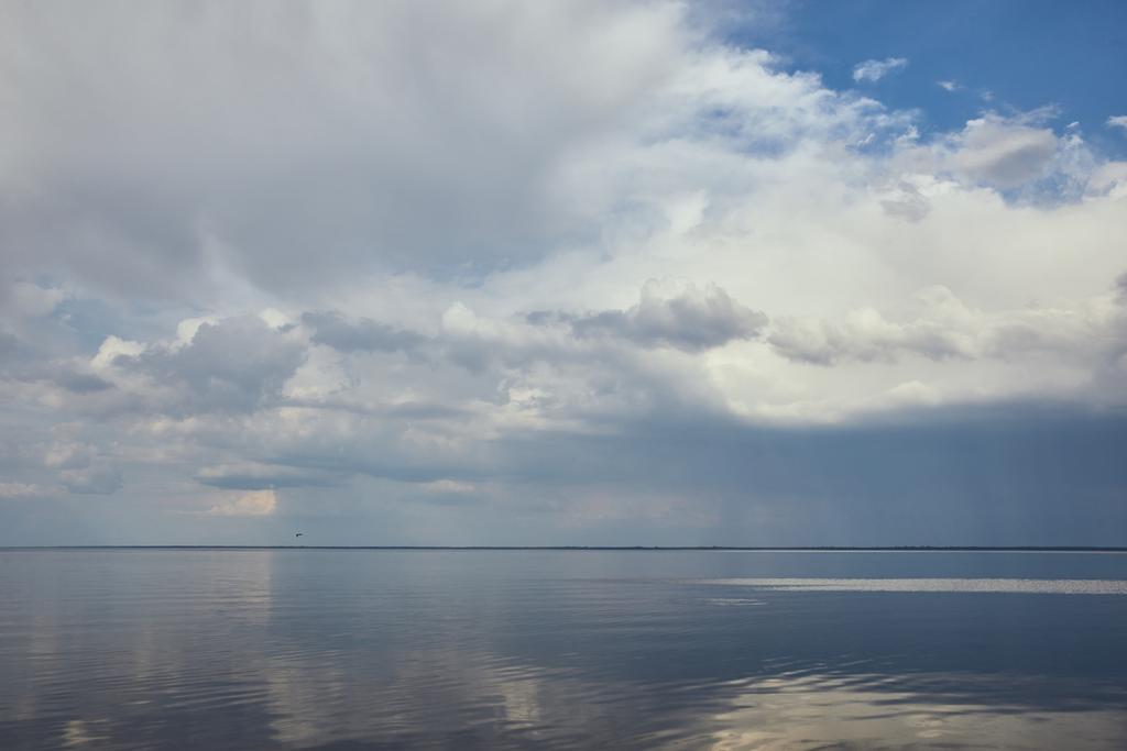 Cielo azul pacífico con nubes blancas reflejadas en el agua del río
 - Foto, imagen