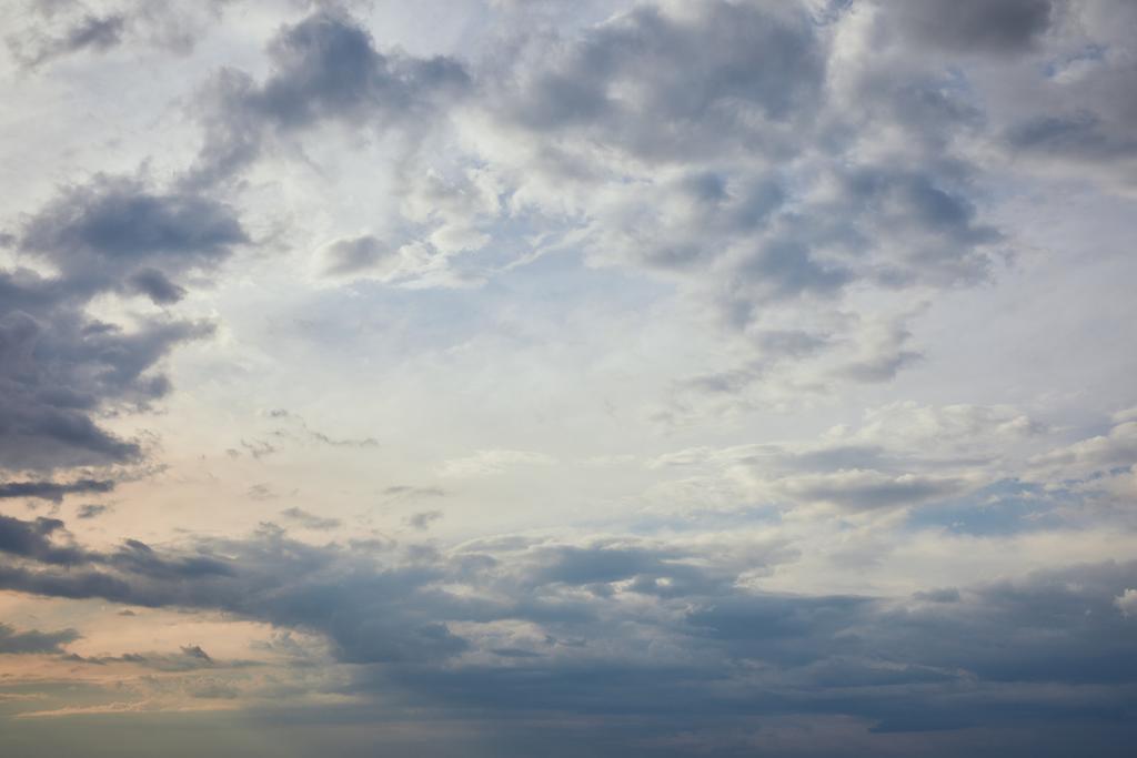 blue clouds on grey sky background and sun rays - Photo, Image