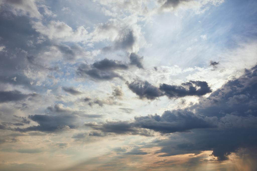 青空の背景に暗い雲と太陽の光 - 写真・画像
