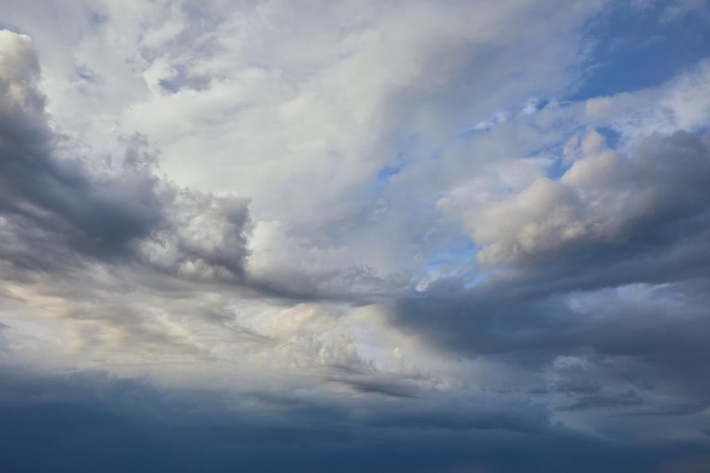 vista del tranquilo fondo gris del cielo con nubes blancas y oscuras
 - Foto, imagen