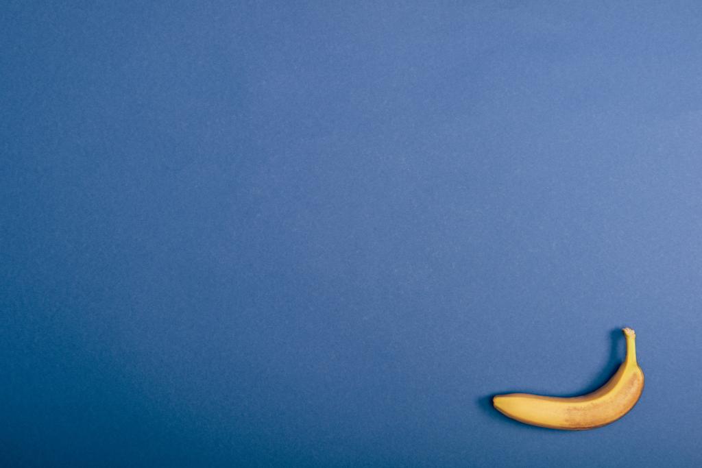 Vista dall'alto di banana matura e gialla su sfondo blu con spazio di copia
 - Foto, immagini