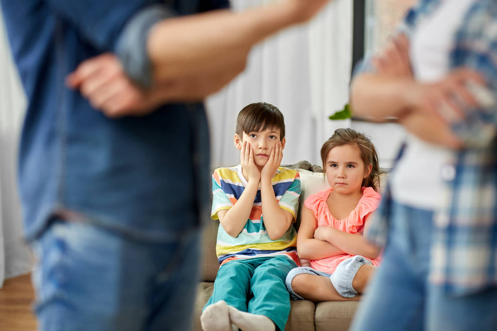 lapset katselevat vanhempiensa riitelevän kotona
 - Valokuva, kuva