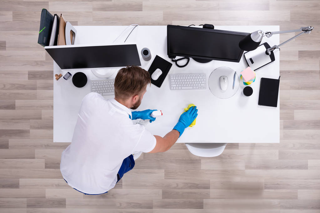 Уборщик чистить белый стол в современном офисе - Фото, изображение