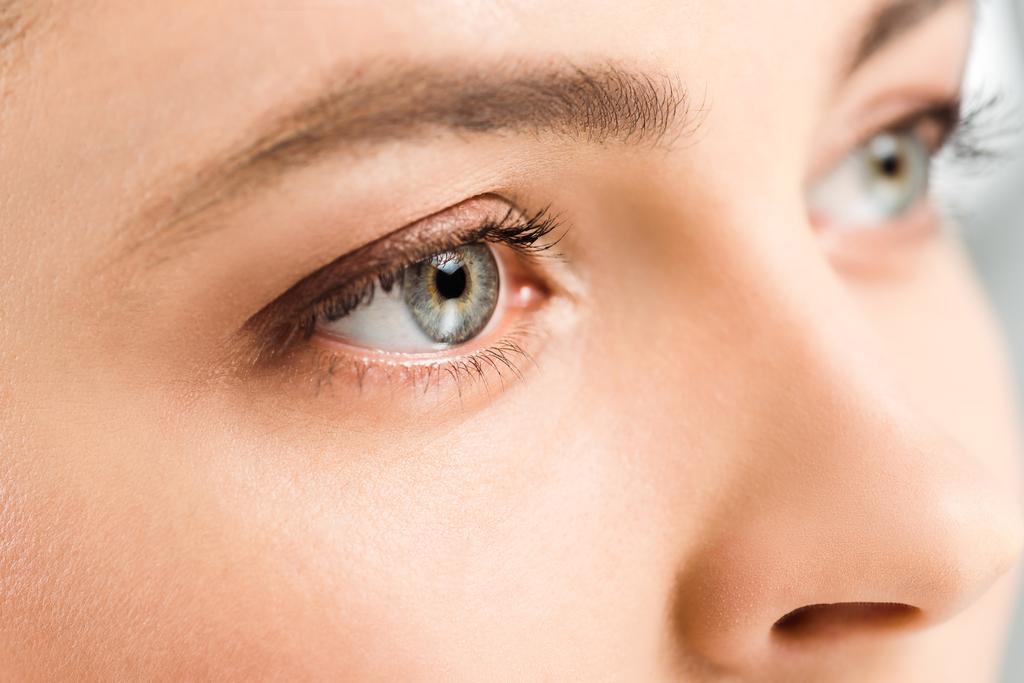 Ausgeschnittene Ansicht einer Frau mit Lidschatten auf wegschauenden Augen  - Foto, Bild
